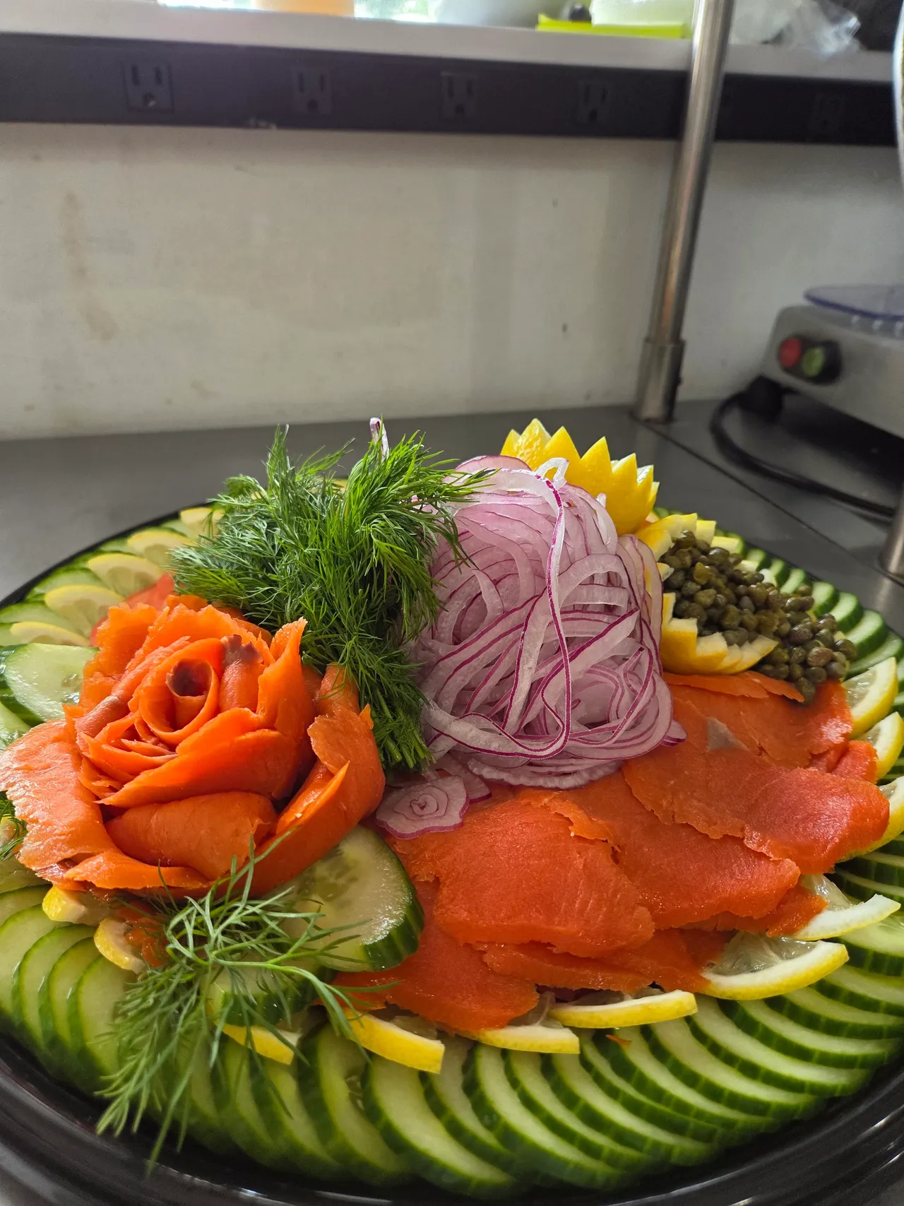 Close-up of a lox platter with a smoked salmon rose and capers