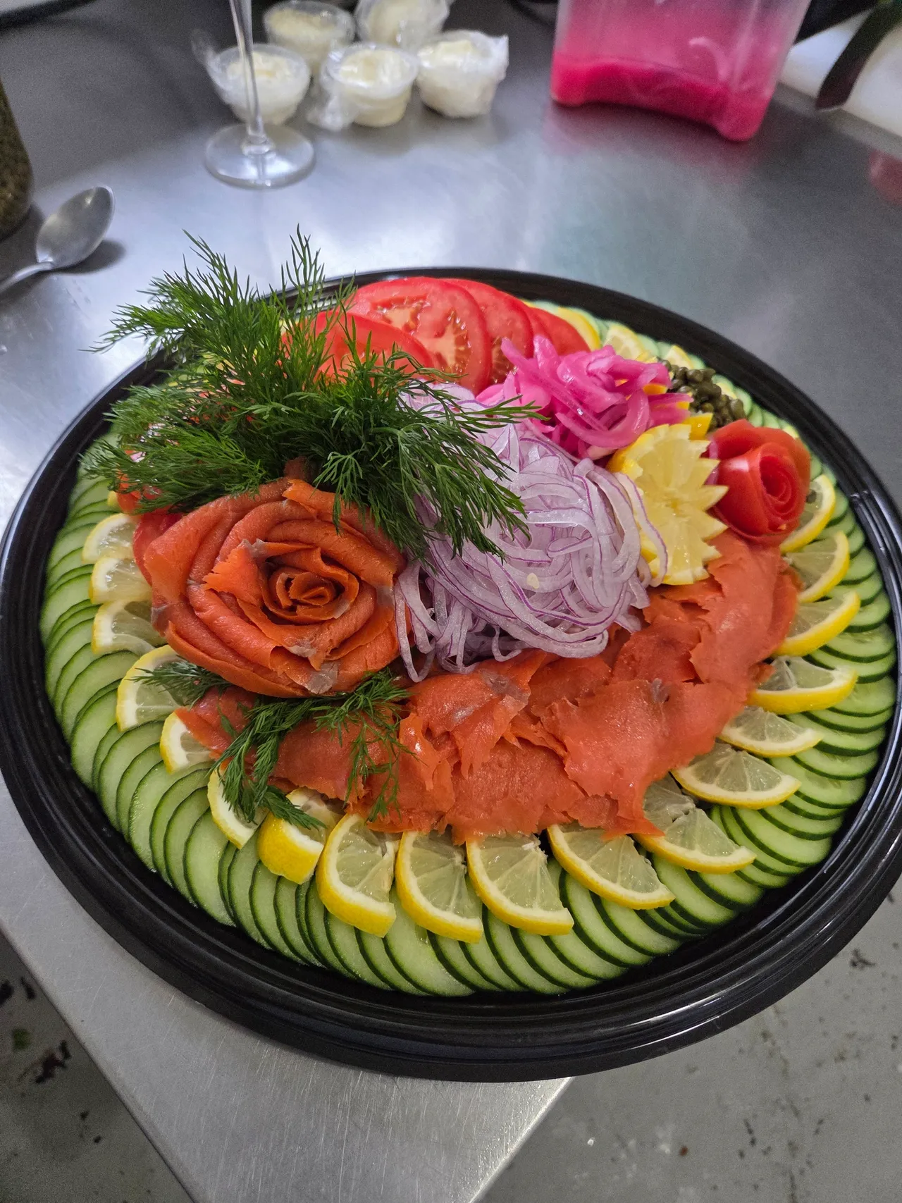 Lox platter from above, ringed with cucumber and lemon
