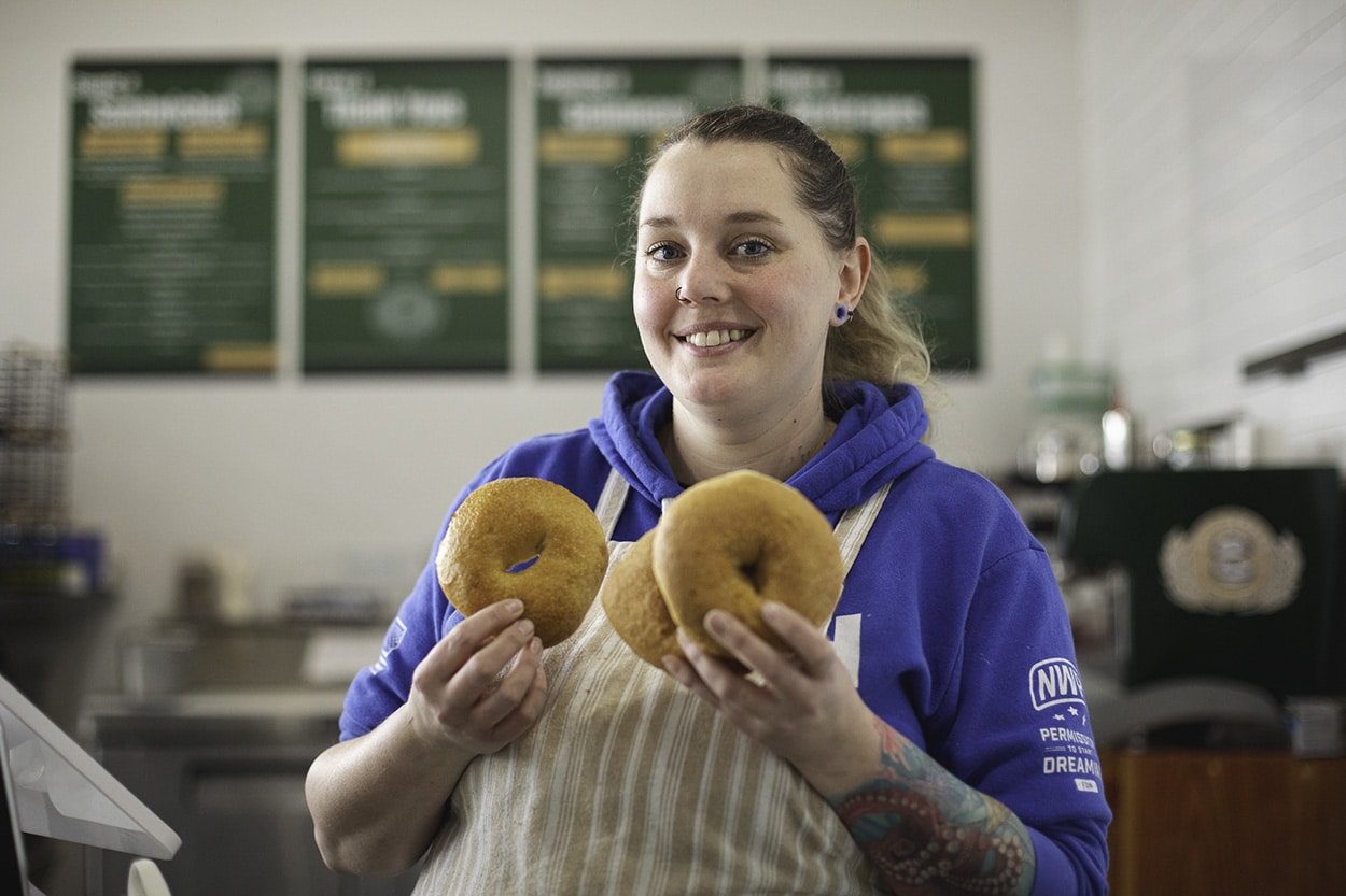 Chef Brittany Erwin, owner of B's Bagels, holding two fresh bagels